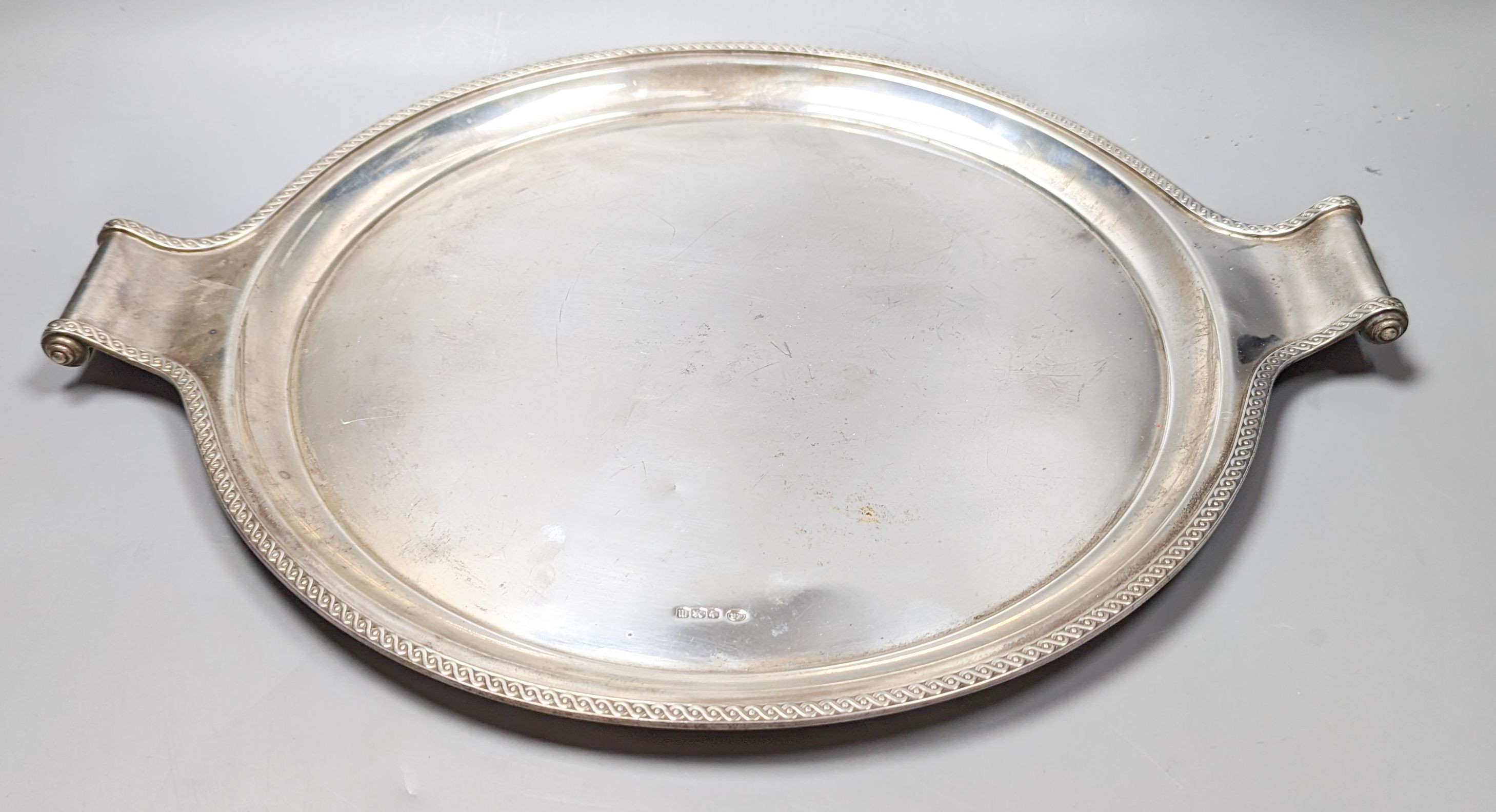 A George V silver circular two handled tray, with engraved border, John Round & Son Ltd, Sheffield, 1929, diameter 45.2cm over handles